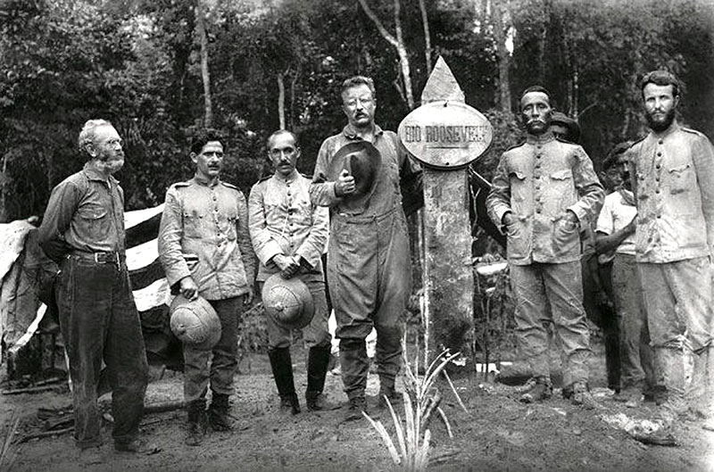 Amazônia, 1914: Theodore Roosevelt (apoiado no marco) e o coronel Cândido Mariano da Silva Rondon (à direita do marco, com as mãos nos bolsos da farda) [Reprodução]