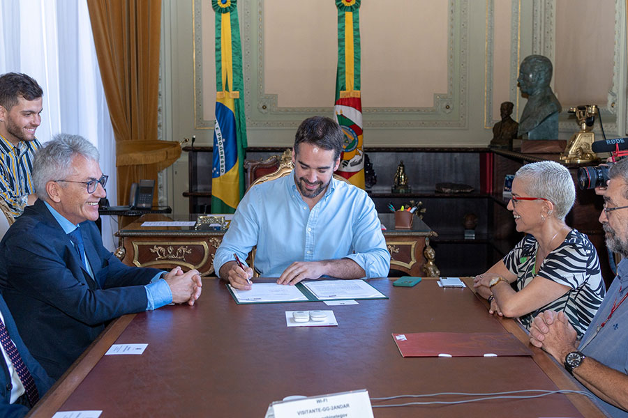 Antonio Hohlfeldt, Eduardo Leite e Beatriz Araujo no ato da assinatura (reprodução Facebook)