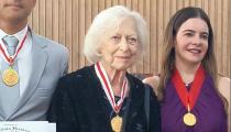 Berenice Menegale recebe a medalha ao lado de outros condecorados (divulgação)